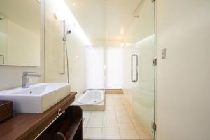 La salle de bains est pourvue d'un lavabo et d'une douche. dans l'établissement Private Villas Ryuz備瀬, à Motobu