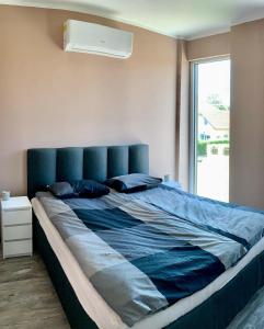 a large bed with a blue headboard in a bedroom at Finfera Villa in Balatonboglár