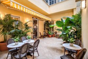 a restaurant with tables and chairs and plants at Tree Charme Augusto Luxury Suites in Rome