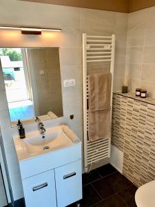 a white bathroom with a sink and a mirror at Finfera Villa in Balatonboglár