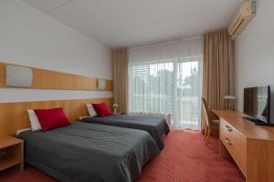 塔尔图Raadimõisa Hotell的有两张床和一台电视的酒店房间