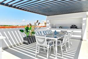 een patio met een tafel en stoelen op een balkon bij Villa Bahia in San Pedro del Pinatar