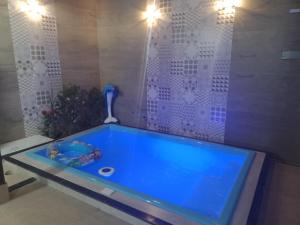 Una gran bañera azul en una habitación con en Doce Lar en Cabo Frío