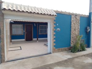 uma casa com uma porta azul e um pátio em Doce Lar em Cabo Frio