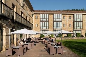 un patio con mesas, sillas y sombrillas en Parador de Argómaniz, en Argómaniz