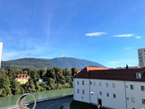 un edificio con vistas al río y a las montañas en City Center Apartment Villach, en Villach