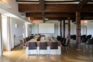 een vergaderzaal met een tafel en stoelen en een projectiescherm bij Parador de Argómaniz in Argómaniz