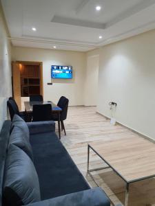 un salon avec un canapé et une télévision sur un mur dans l'établissement Les Belles Residences E, à Tanger
