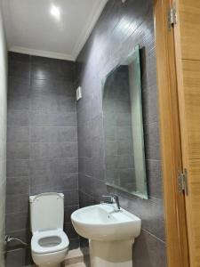 une salle de bain avec toilettes, lavabo et miroir dans l'établissement Les Belles Residences E, à Tanger
