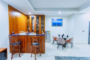 un bar en una habitación con mesa y sillas en Alisa Hotel Tema en Tema