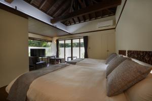 sypialnia z dużym łóżkiem i biurkiem w obiekcie Private Villas Ryuz備瀬 w mieście Motobu