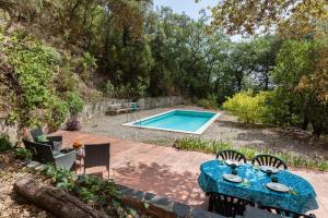 um pátio com uma mesa e uma piscina em Casa en Montseny con piscina em Sant Pere de Vilamajor