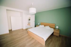a bedroom with a bed and a green wall at Dream House Apartments in Oradea