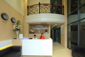 two people standing at a counter in a building at Hung Cuong Hotel in Chau Doc