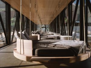 a row of beds in a room with large windows at Lindenhof Pure Luxury & Spa DolceVita Resort in Naturno