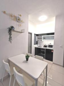 a white kitchen with a white table and chairs at 4 Traders Garden 1 Bedroom Pool View Netflix WiFi in Cheras