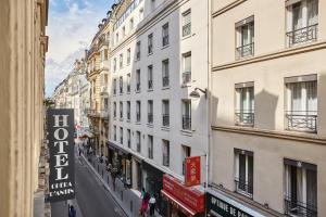 a city street with buildings and people walking down the street at Hotel Opéra d'Antin in Paris
