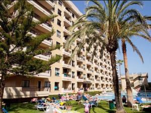 ein großes Gebäude mit Palmen und Menschen am Strand in der Unterkunft Apartamento Nuevo RONDA IV in Fuengirola