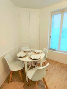 biała jadalnia z białym stołem i krzesłami w obiekcie Heteroclite w mieście Auxerre
