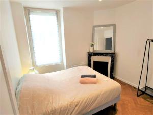 biała sypialnia z łóżkiem i lustrem w obiekcie Heteroclite w mieście Auxerre