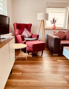 a living room with a red chair and a couch at Ferienhaus Griede in Mörsdorf