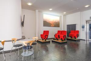 a waiting room with red chairs and a table at Jugendherberge Stuttgart International in Stuttgart