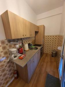 mała kuchnia z drewnianymi szafkami i zlewem w obiekcie Villa Fer Forze you have the feeling of your own holiday home w mieście Asprovalta