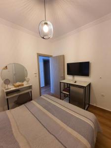 Schlafzimmer mit einem Bett, einem Schreibtisch und einem TV in der Unterkunft Villa Fer Forze you have the feeling of your own holiday home in Asprovalta