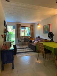Casa Aconchego - Arraial D Ajuda- Bahia في ارايال دايودا: غرفة معيشة مع أريكة وطاولة
