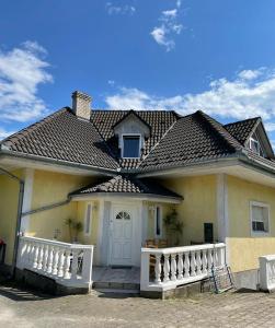 巴拉頓納喀拉洽的住宿－Szilvia Ház Balatonakarattya，前面有白色围栏的黄色房子