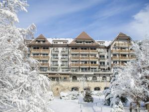 a hotel in the winter with snow covered trees at Park Gstaad in Gstaad