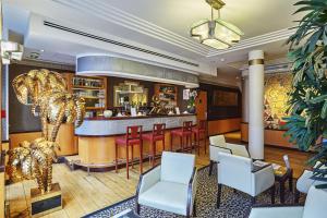 a bar in a hotel lobby with red chairs and a bar counter at Hotel Opéra d'Antin in Paris