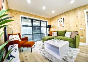 a living room with a green couch and a table at Green Mews 2 with Free Parking - By My Getaways in Brighton & Hove