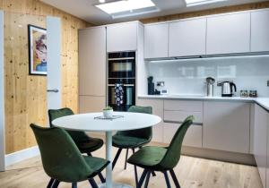 a kitchen with a white table and green chairs at Green Mews 2 with Free Parking - By My Getaways in Brighton & Hove