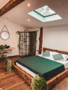 een slaapkamer met een groot bed en een dakraam bij Utopia by NorAtlas Heritage - Adults Only in Buzau