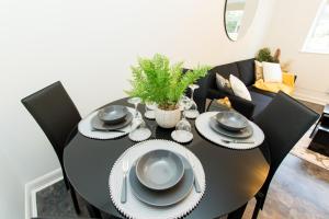 einen schwarzen Esstisch mit schwarzen Stühlen in der Unterkunft K Suites - Flat 114 Fulbridge Road in Peterborough