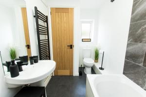 a bathroom with two sinks and a toilet at K Suites - Flat 114 Fulbridge Road in Peterborough