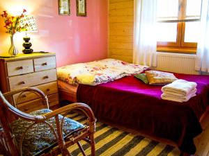 a bedroom with a bed and a dresser and a chair at Karkonoskie Siodło in Kostrzyca