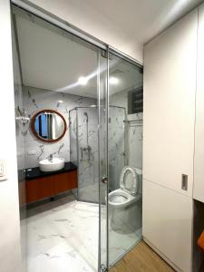 een badkamer met een toilet, een wastafel en een spiegel bij Era Cozy Apartment in Hanoi