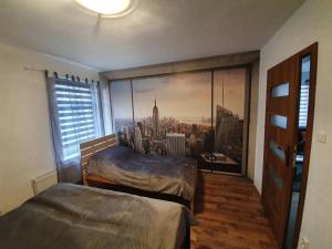 a bedroom with two beds and a large window at Apartamenty Wałowa 11 in Leszno