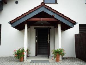 a entrance to a building with two potted plants at Agroturystyka Zaborski Sad in Zabór