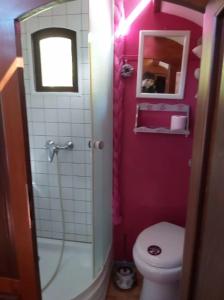La salle de bains rose est pourvue de toilettes et d'une douche. dans l'établissement La roulotte d'alany, à Grayan-et-lʼHôpital