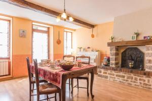 a dining room with a table and a fireplace at Au coeur du Chat Perché in Arnay-le-Duc