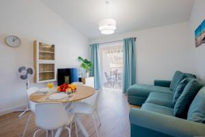 salon ze stołem i niebieską kanapą w obiekcie Bright & Stylish Apartment in Chipeque, Los Cristianos w Aronie
