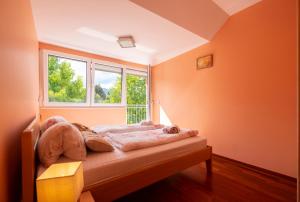 um quarto com paredes cor-de-laranja e uma cama com uma janela em Apartments Apple Garden 4P em Bled
