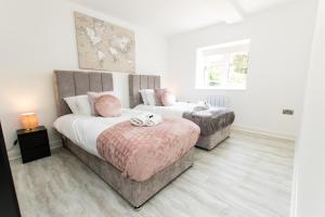 1 Schlafzimmer mit 2 Betten, einem Sofa und einem Fenster in der Unterkunft K Suites - Flat 110 Fulbridge Road in Peterborough