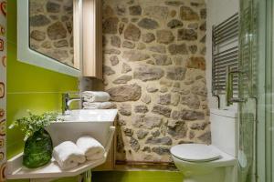 a bathroom with a sink and a stone wall at Casa Rural Soleada para una Escapada Tranquila in Ceceda de Abajo