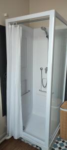 La salle de bains est pourvue d'une douche avec rideau de douche. dans l'établissement Les Cocons de Stéphanie avec balcon, à Vichy