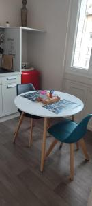 a table and two chairs in a kitchen at Les Cocons de Stéphanie avec balcon in Vichy