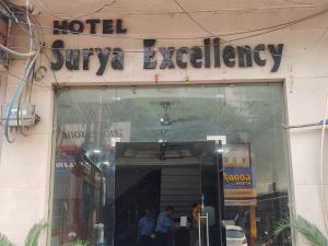 賈姆穆的住宿－Hotel Surya Excellency By WB Inn，大楼上酒店导航标志前的商店